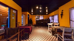 Een restaurant met een patroon vloer, houten meubels en een bar.