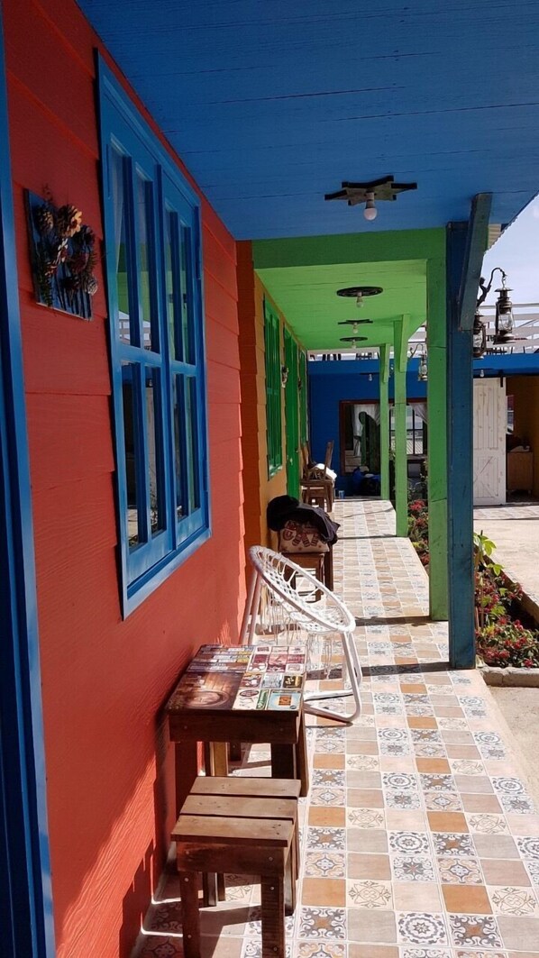 A colorful outdoor seating area with a tiled floor and a covered walkway.