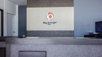 Una mesa de recepción con un logotipo de 'big orange Jitro' en la pared.