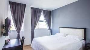 Quarto com cama, escrivaninha e cadeira.