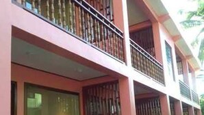 A multi-story building with balconies, large windows, and a wooden deck area. - Kyaw Ngapali Lodge (Ngapali)