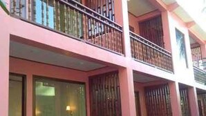 A multi-story building with balconies, large windows, and a wooden deck area. - Kyaw Ngapali Lodge (Ngapali)