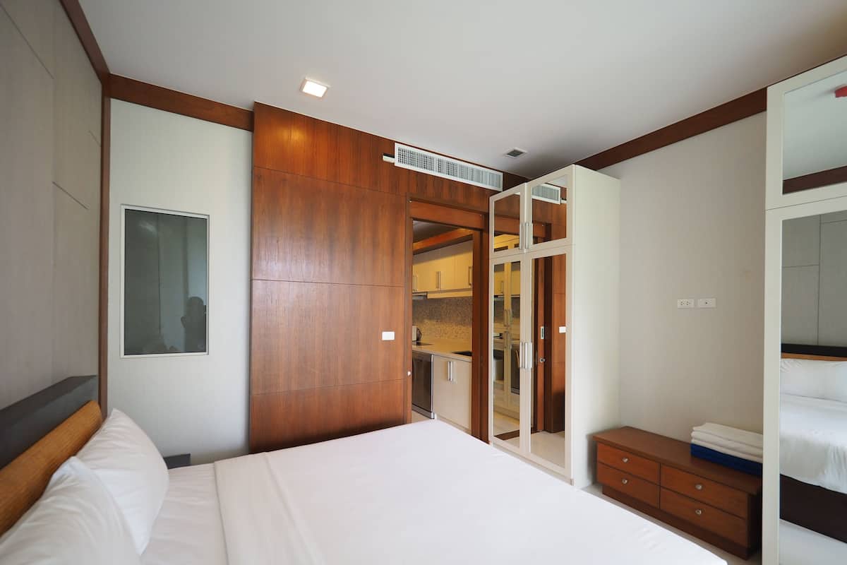 Un dormitorio con una cama grande, un armario de madera y un vestidor.