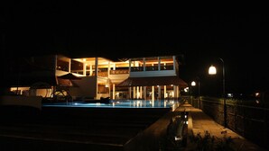 Un bâtiment à deux étages avec une piscine devant.
