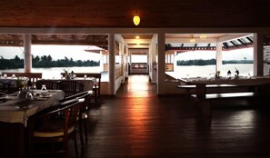 A restaurant with a wooden interior, large windows, and a view of the water. - Paloma Backwater Resorts (Kuttanad Taluk)