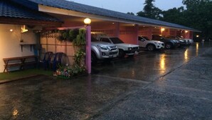 A covered parking area with several cars parked under a roof. - PKhotelresort (Prachin Buri)