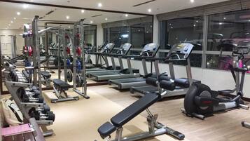 Una palestra con tapis roulant, macchinari per pesi e panche.