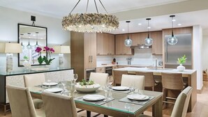A modern kitchen with wooden cabinets, a stainless steel refrigerator, and pendant lights. - Timbers Kauai (Lihue)