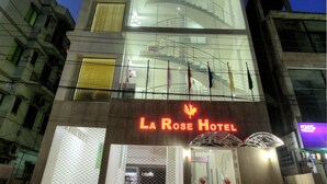Un hôtel moderne doté d’une façade en verre remarquable, de plusieurs étages et d’une entrée bien visible, avec une enseigne rouge.