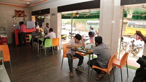 Un restaurante con mesas en el interior, una barra para ordenar y vistas a la calle.