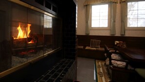Una sala de estar con chimenea, un sofá y una mesa de centro.