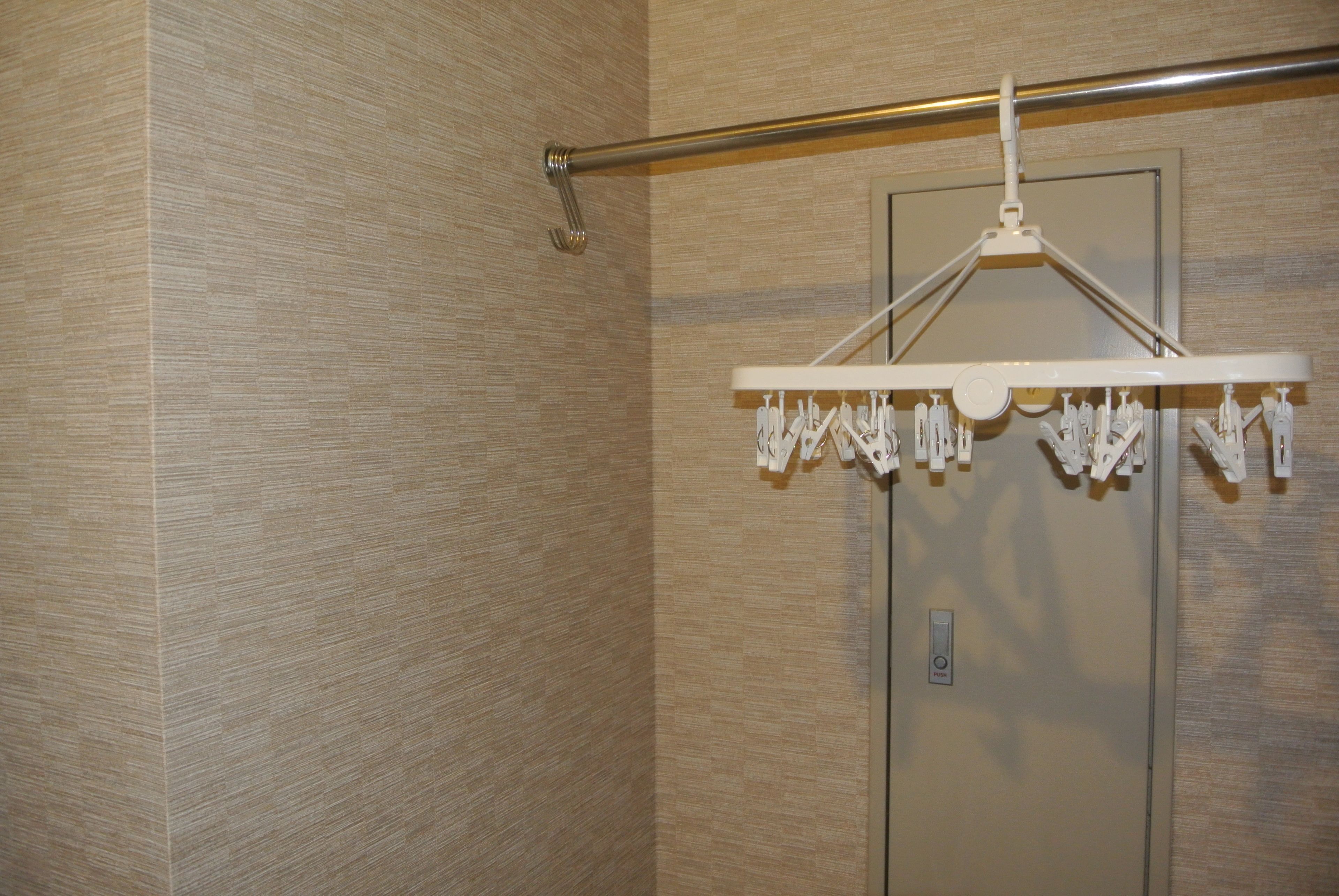 A shower area with a towel rack and a door.