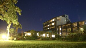 A multi-story hotel with a modern design, featuring balconies and large windows.