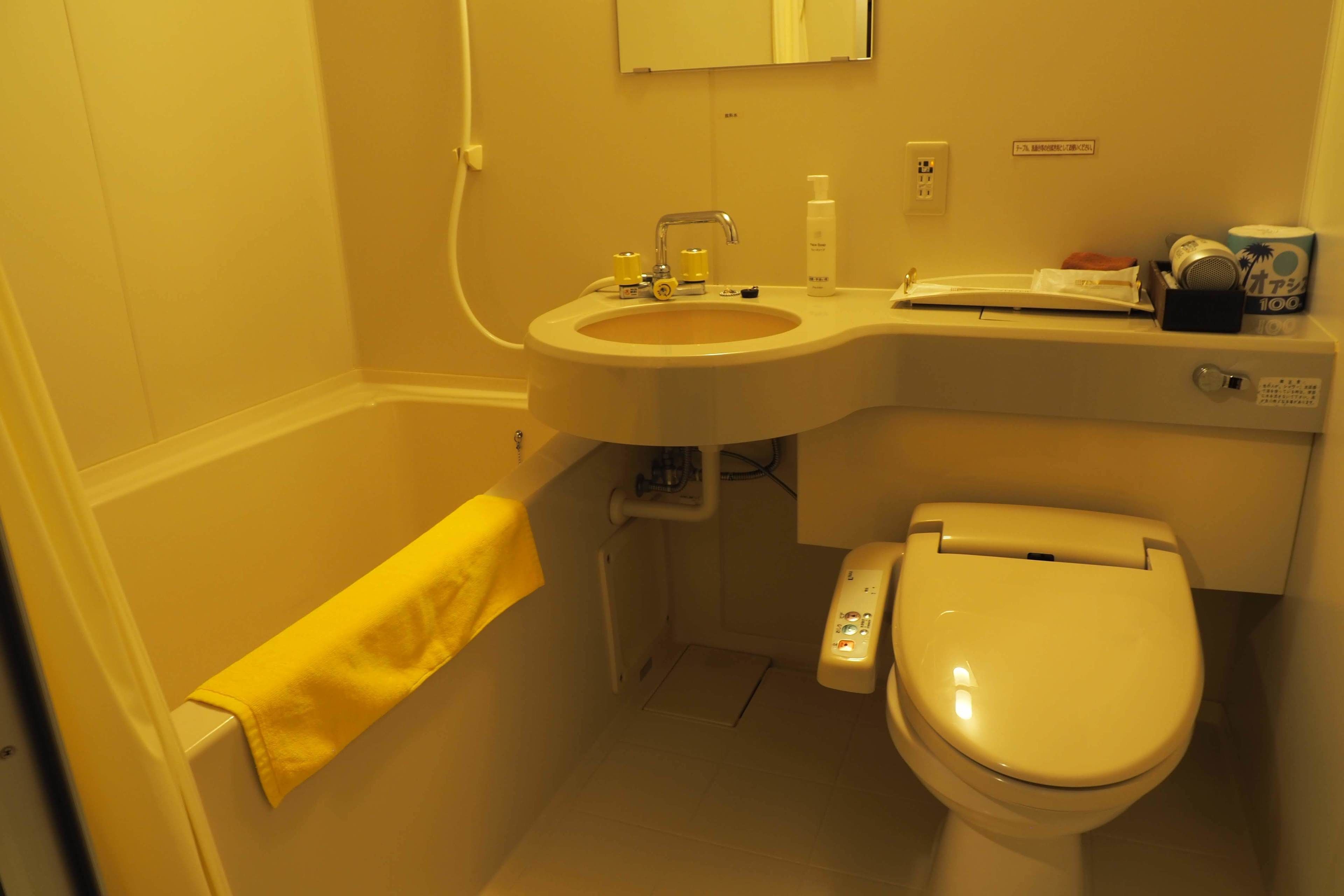 A small bathroom with a sink, toilet, and towel rack.
