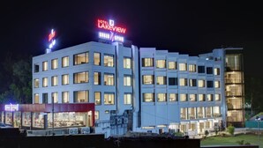 A multi-story hotel with illuminated signage, large windows, and a modern architectural design. - Hotel Lakeview (Ahwa)