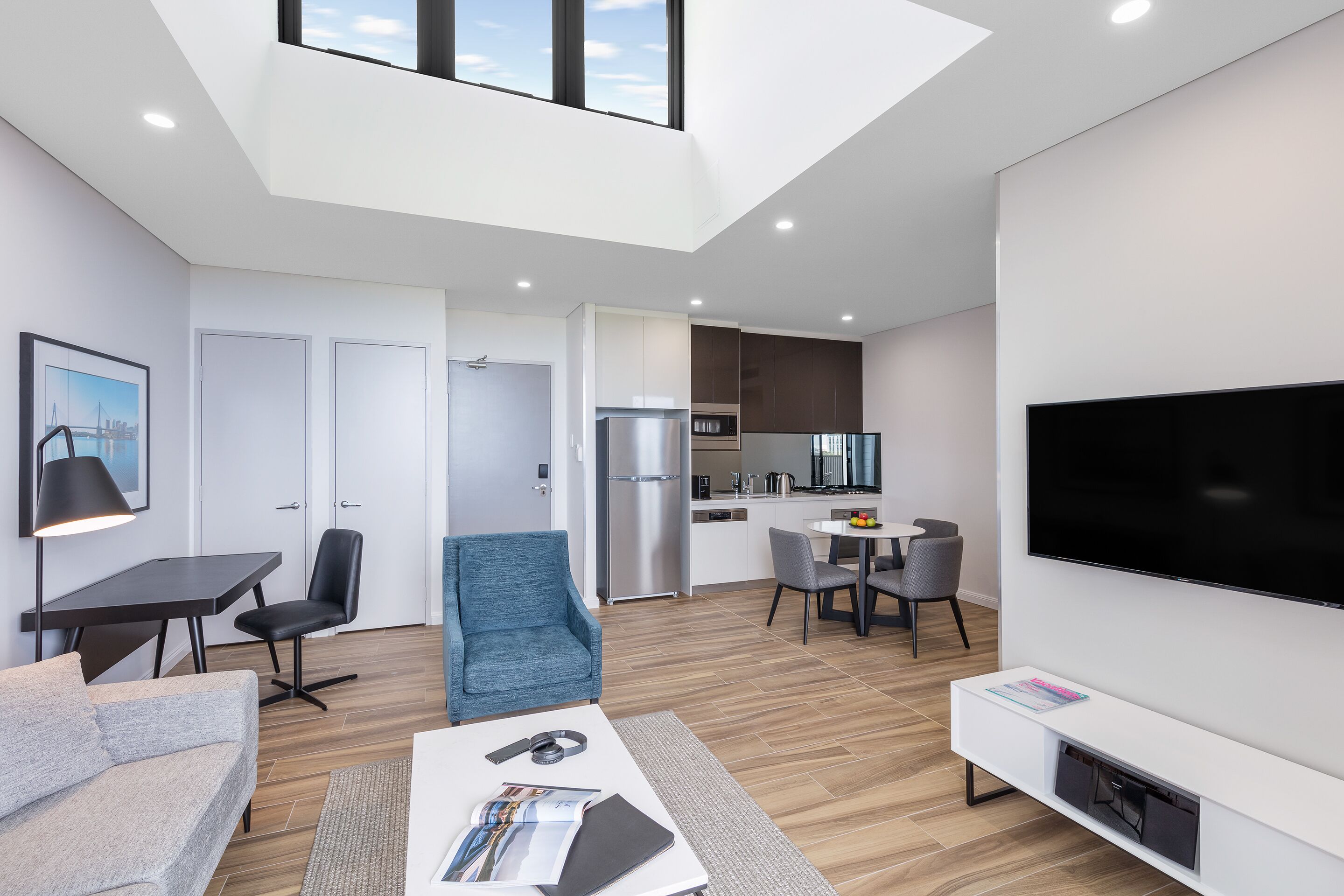 A modern apartment with a dining area, kitchen, and living room.