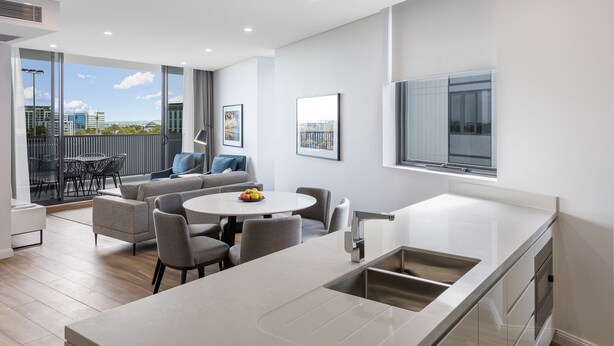 Un apartament modern amb cuina, zona de menjador i un balcó amb vistes a la ciutat.