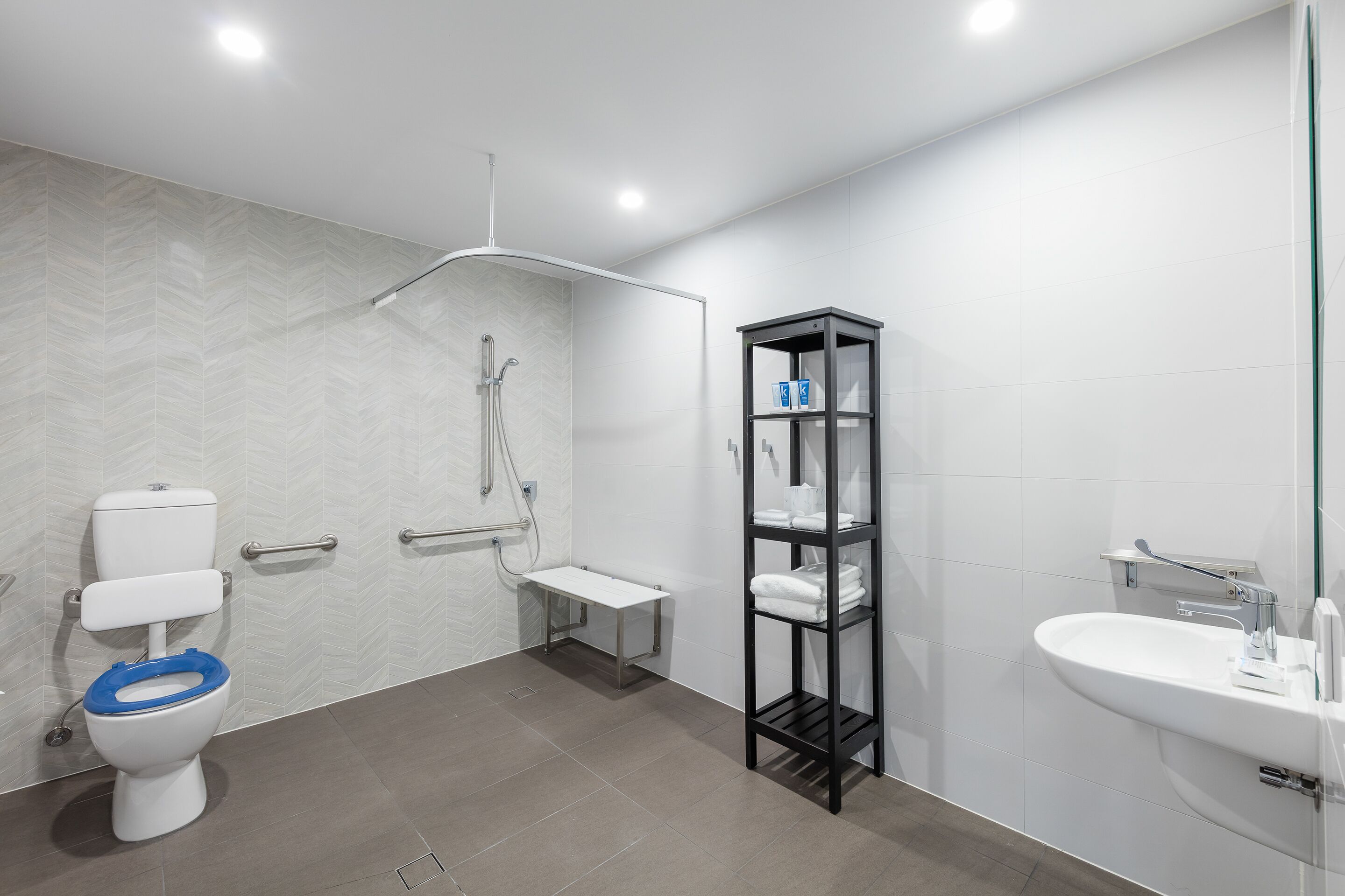 Un baño moderno con inodoro, ducha y lavabo.