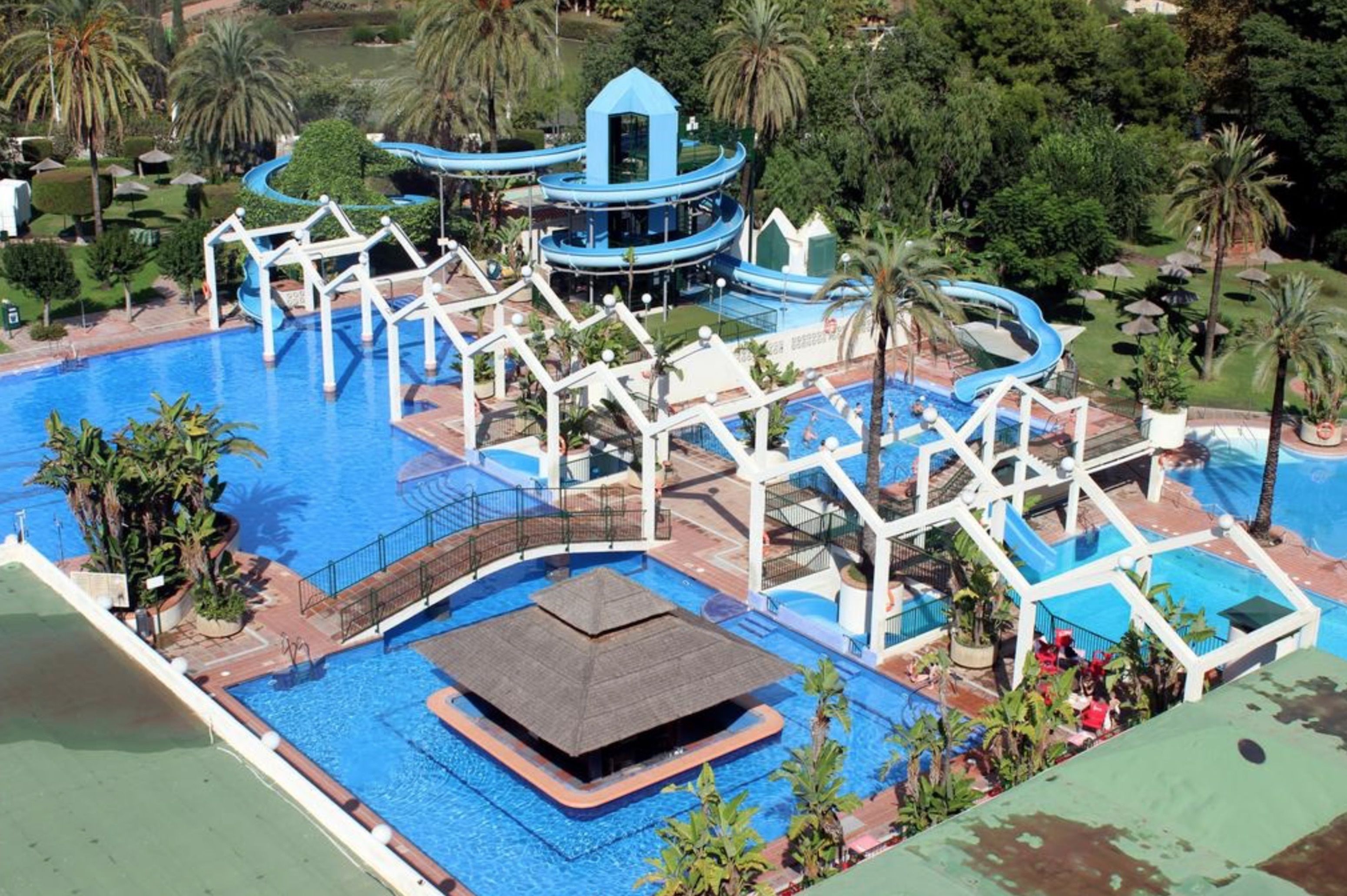 A large outdoor swimming pool with multiple slides and a central water tower.