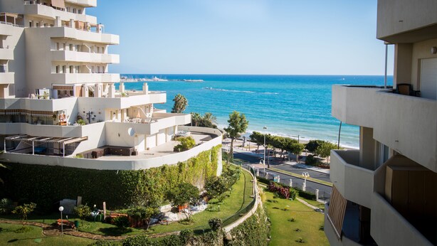 Ein modernes Hotel mit mehreren Balkonen und Blick auf die Küste.