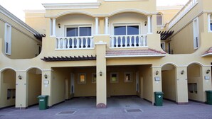A multi-story building with balconies, a tiled roof, and a courtyard. - Piks Key- Al Hamra Village (Ras Al Khaimah)