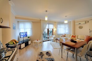 A modern living room with a TV, dining table, and seating area. - Kaya Apart Point (Istanbul)