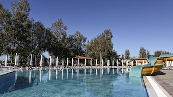 Alberca techada, alberca al aire libre y sombrillas en la alberca