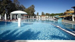 A swimming pool with a water slide, lounge chairs, and a pavilion. - Halic Park Hotel (Ayvalik)