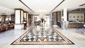 A hotel lobby with a check-in counter, seating area, and a chandelier. - Halic Park Hotel (Ayvalik)