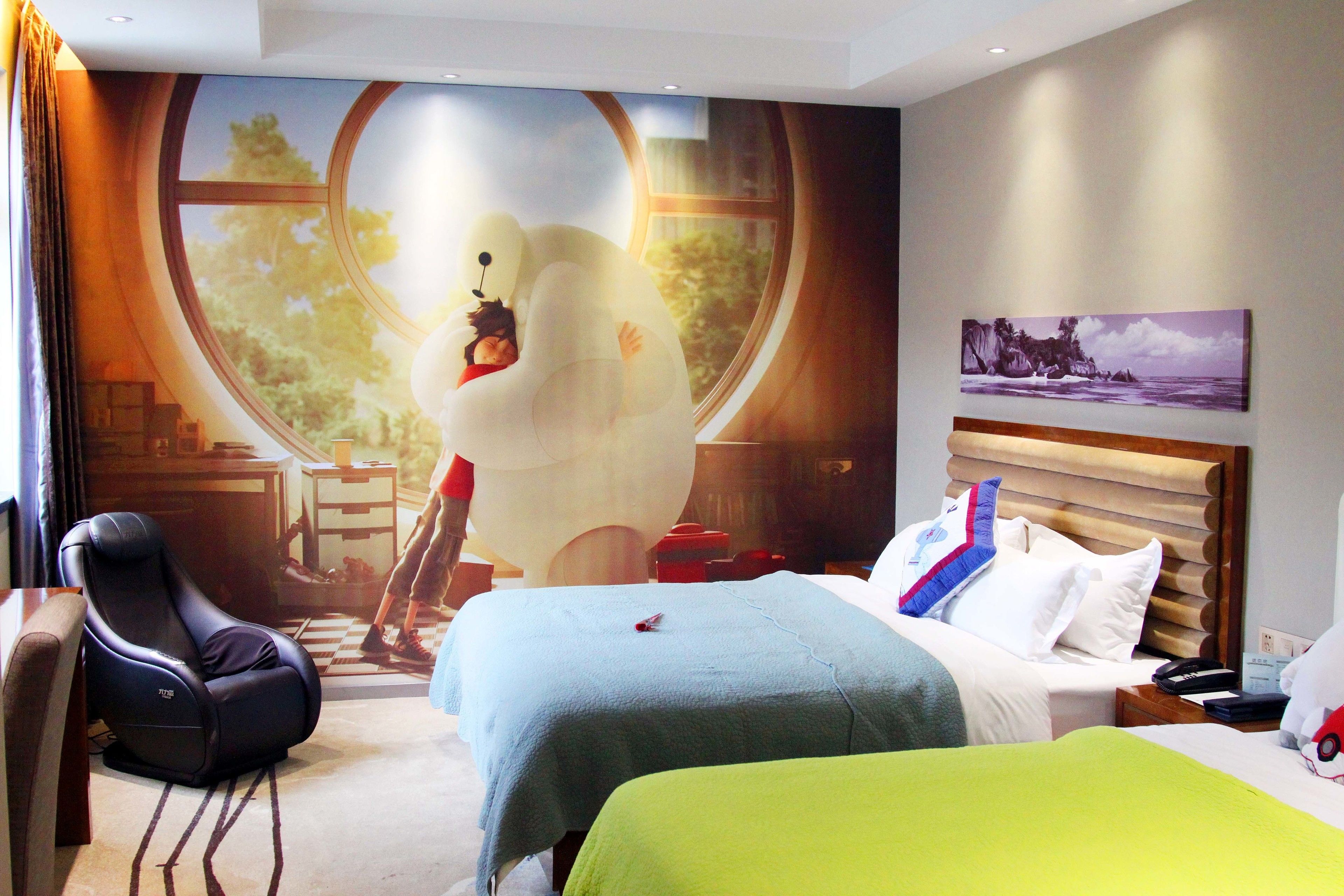 Habitación de hotel con dos camas, una silla de masaje, un ventanal grande y un cuadro en la pared.