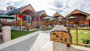 A row of wooden cabins with a sign indicating a small house. - Happy House (Liuqiu)