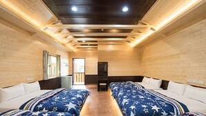 A room with two beds, wooden walls, and a ceiling with recessed lighting. - Happy House (Liuqiu)