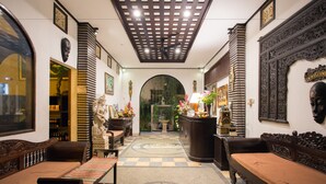 A traditional interior with a central archway, wooden furniture, and decorative items. - Grand Sehati & Spa Ubud (Ubud)