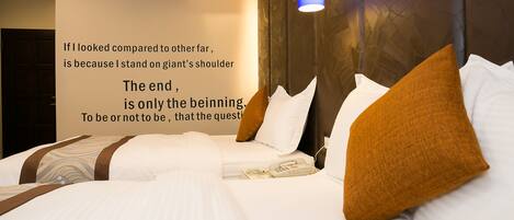 Een hotelkamer met een groot bed, een bedtelefoon en een motiverende quote op de muur.