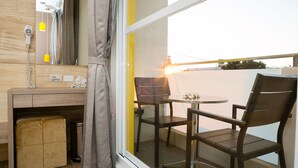 A balcony with a wooden desk, two chairs, and a small table. - Bai Sha Tan Cottage (Hengchun)