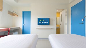 A hotel room with two beds, a desk, a chair, a TV mounted on the wall, and a bathroom visible through an open door. - Hop Inn Nakhon Sawan (Nakhon Sawan)