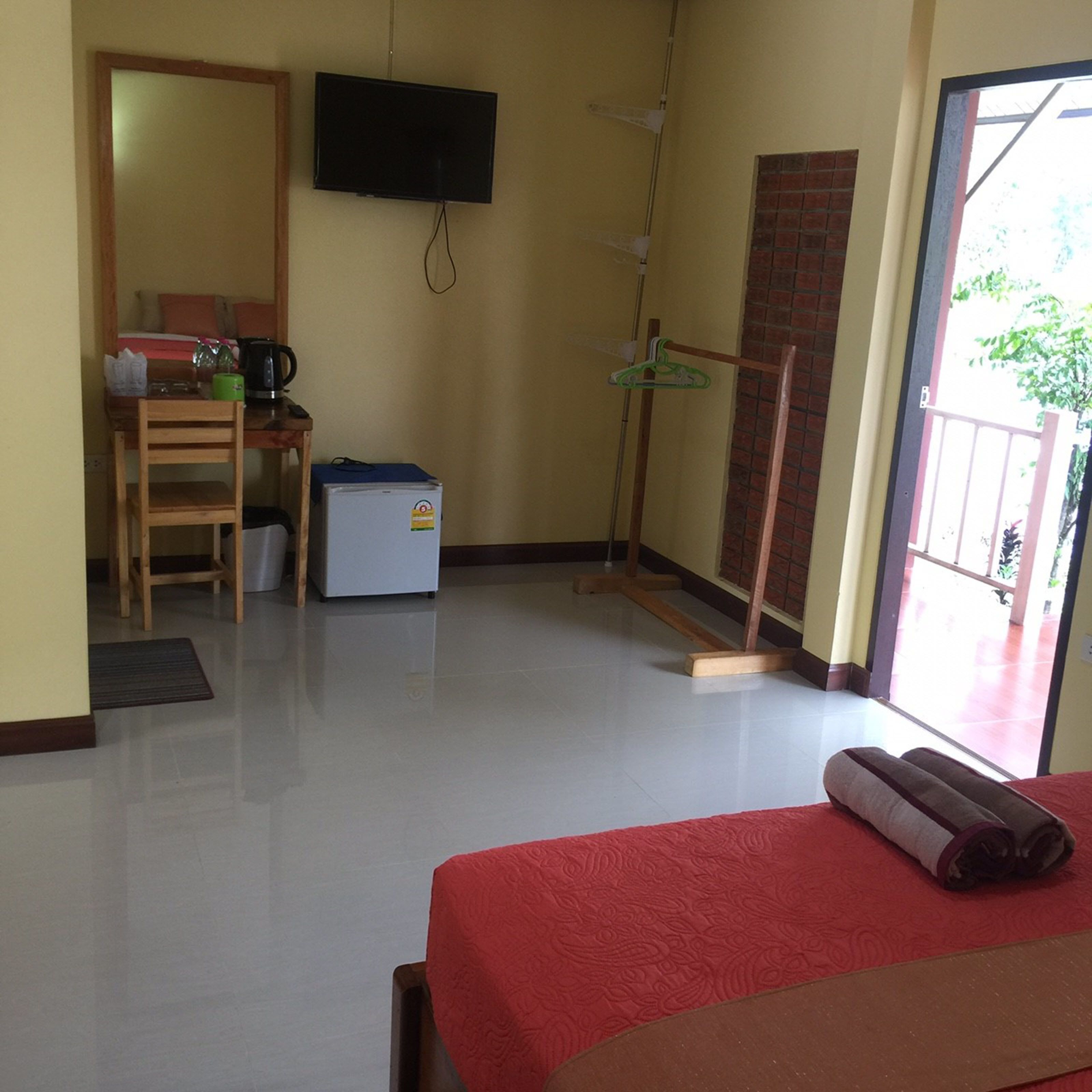 A room with a bed, a desk, a television, and a door leading outside.