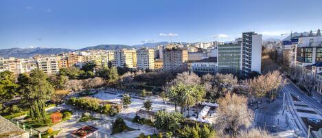 A cityscape with a mix of residential and commercial buildings, a central park area, and a clear sky.