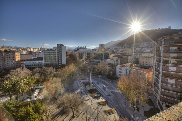 A cityscape with a prominent building featuring a central plaza, surrounded by other buildings and a clear sky. - Condestable Iranzo (Jaén)