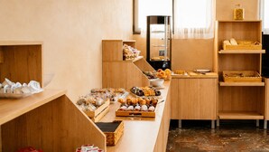 A buffet setup with various food items, wooden furniture, and a coffee machine.