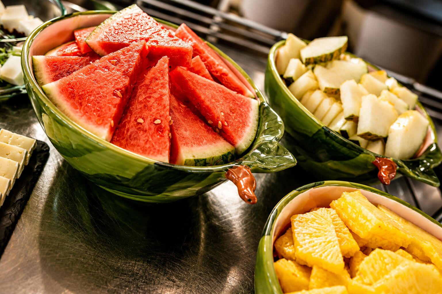 Una mesa con frutas variadas en cuencos, como sandía y piña.