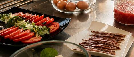 A buffet setup with various food items including tomatoes, eggs, and a salad.