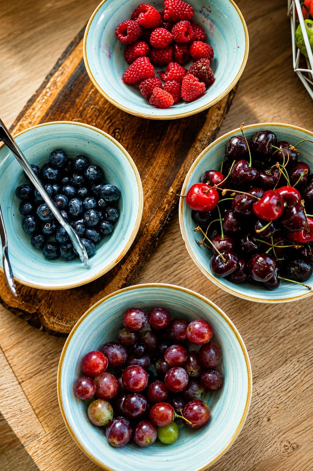 Tres tazones de fruta sobre una superficie de madera.