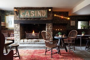 A cozy interior with a fireplace, rustic stone walls, and wooden furniture. - Artist Residence Oxfordshire (Witney)