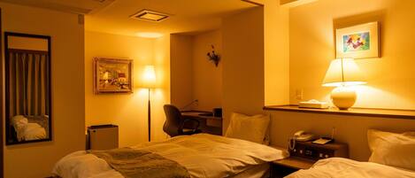 A hotel room with two beds, a desk, a chair, a lamp, a painting, and a telephone.