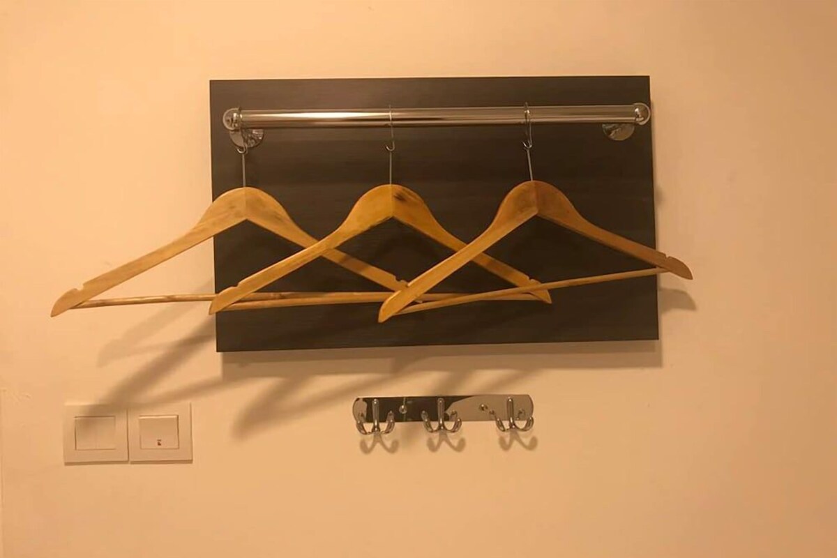 Ein Wandhaken mit drei Holzaufhänger und einer darunterliegenden Metallstange.