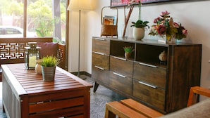 Ein Holztisch mit einem Blumentopf, einer Lampe und einem Schrank mit Dekorationen.