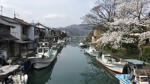 Um canal estreito flanqueado por edifícios tradicionais e barcos.