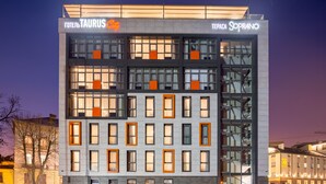A modern building with multiple floors, featuring a prominent sign for 'Hotel Taurus City' and 'Tepeca Soprano'. - Taurus City (Lviv)
