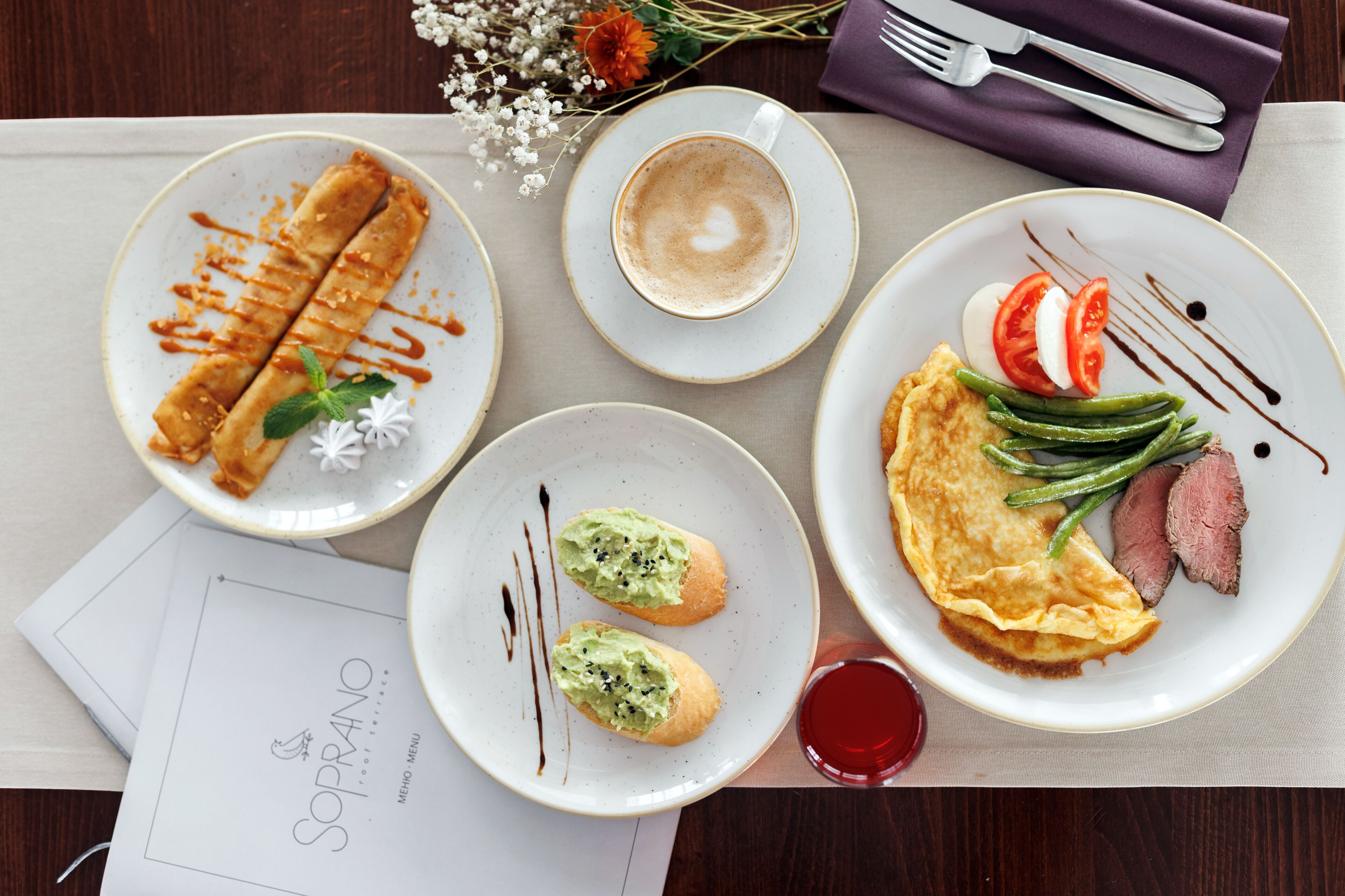 Una mesa con platos de comida, una taza de café y un menú.